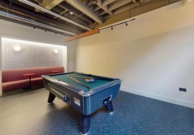 Pool table with balls and cues red sofa playing area at iQ Hoxton in London Student Accommodation