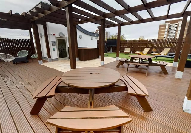 Outdoor seating area with picnic tables and chairs exterior at iQ Hoxton in London Student Accommodation