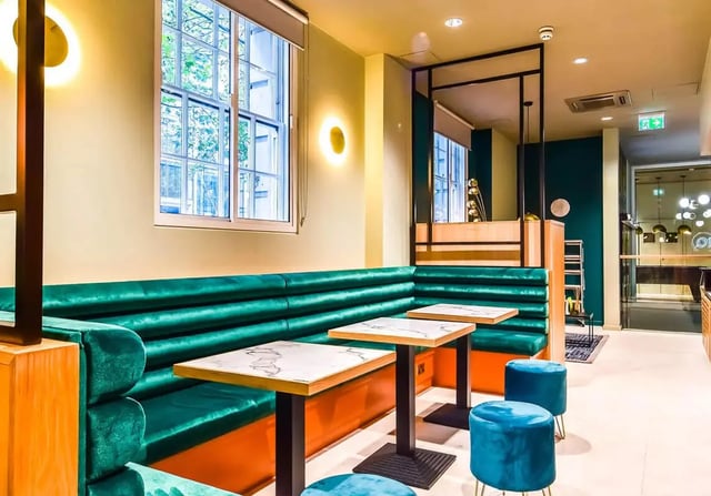 Green booth seating with marble tables lounge area at iQ Bloomsbury in London Student Accommodation