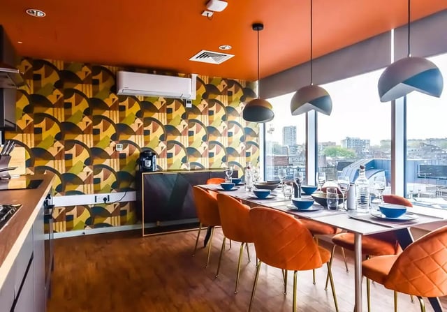 Dining table set with orange chairs kitchen area. at iQ Bloomsbury in London Student Accommodation