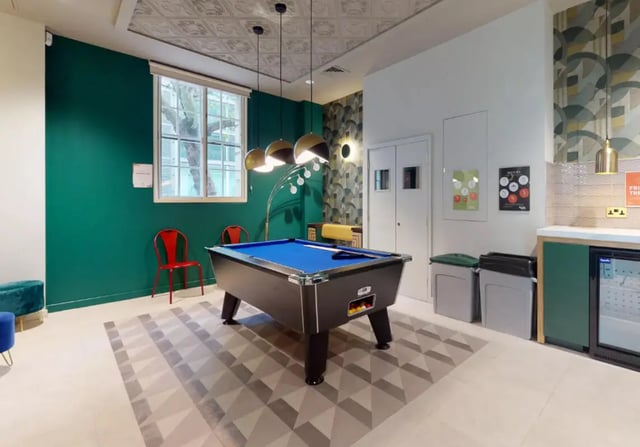 Pool table red chairs green wall common area at iQ Bloomsbury in London Student Accommodation