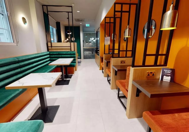 Green booths white tables orange booths study area at iQ Bloomsbury in London Student Accommodation