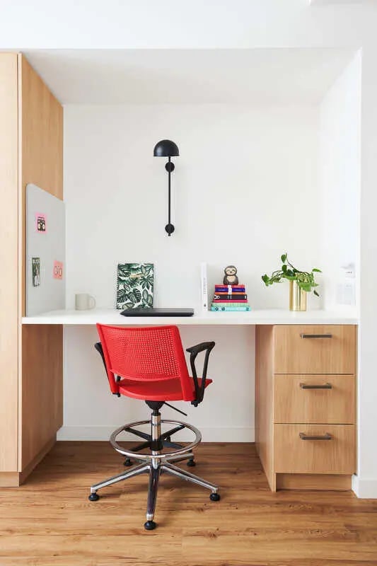 Desk with red chair and wooden cabinets study area at Scape Uni Square in Melbourne Student Accommodation