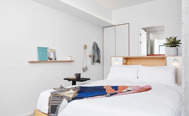 Bed with colorful throw and wall decor bedroom at Scape Franklin in Melbourne Student Accommodation