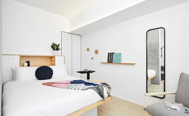Bed with navy pillow and blanket bedroom at Scape Franklin in Melbourne Student Accommodation