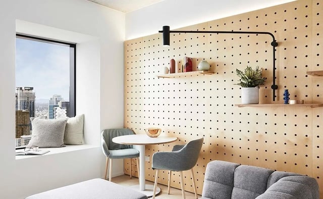 Table chairs pillows window city view living room at Scape Franklin in Melbourne Student Accommodation