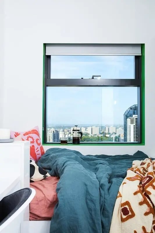 Bed pillows French press and city view bedroom at Scape Franklin in Melbourne Student Accommodation