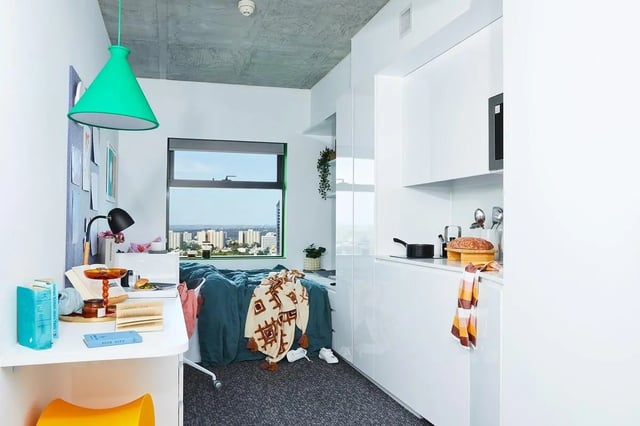Bed desk kitchen area with city view bedroom at Scape Franklin in Melbourne Student Accommodation