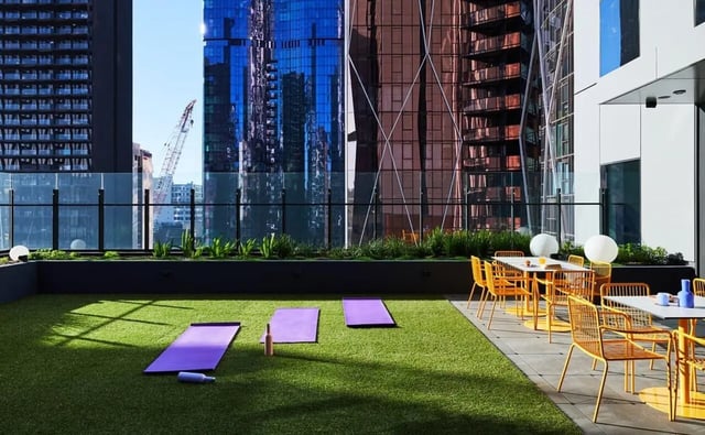 Yoga mats on lawn with outdoor seating exterior at Scape Franklin in Melbourne Student Accommodation
