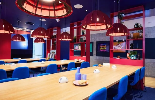 Wooden tables blue chairs red shelves study area at Scape Franklin in Melbourne Student Accommodation
