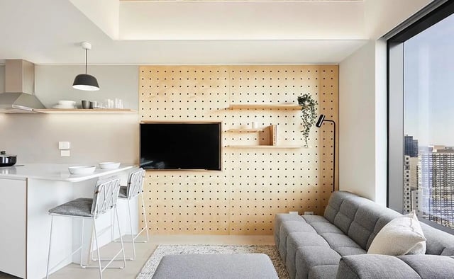 Modern kitchen island bar stools television and sofa living room at Scape Franklin in Melbourne Student Accommodation