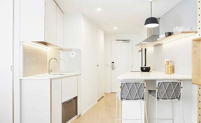 Modern kitchen with sink stools and appliances kitchen at Scape Franklin in Melbourne Student Accommodation