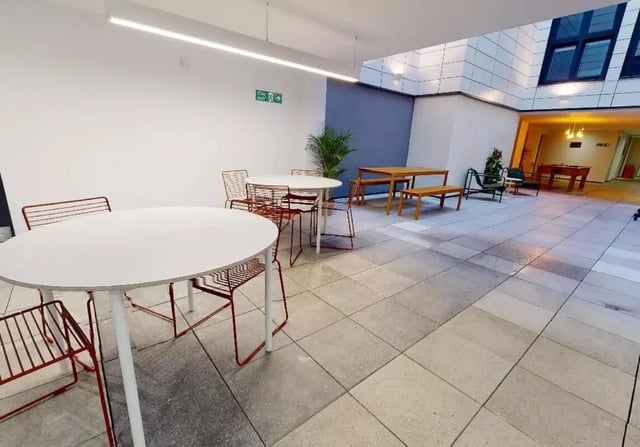 White tables and red chairs communal area at iQ Steel in Sheffield Student Accommodation