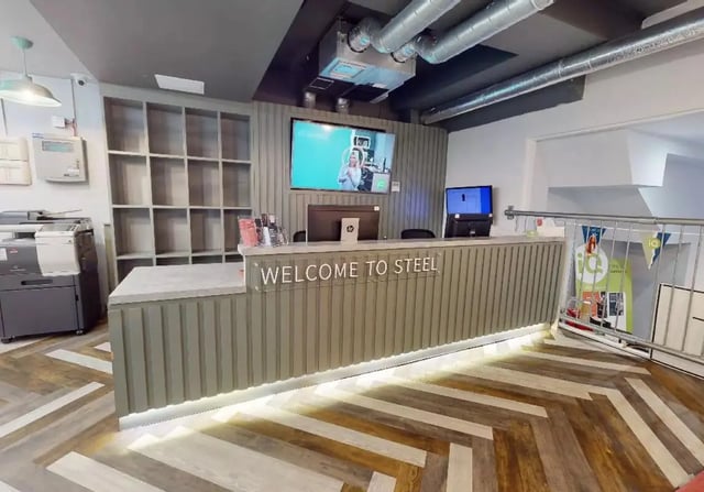 Reception desk with shelving printers and monitors reception area at iQ Steel in Sheffield Student Accommodation