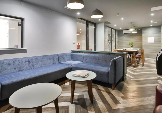Blue sectional sofa coffee tables dining table living room at iQ Steel in Sheffield Student Accommodation