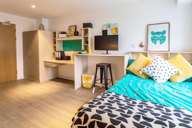 Desk monitor stool bed and pillows bedroom at Holden Court in Brighton Student Accommodation