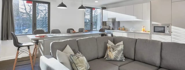 Sofa kitchen counter and dining table living area at The Glassworks Leicester in Leicester Student Accommodation