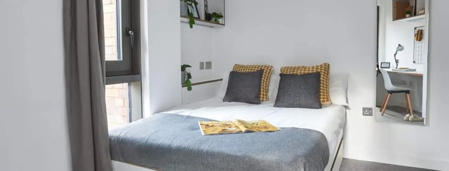 Bed with pillows desk with chair bedroom study area at The Glassworks Leicester in Leicester Student Accommodation