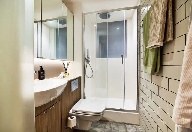 Sink toilet shower glass door towels bathroom at Vita Student Manchester Circle Square in Manchester Student Accommodation