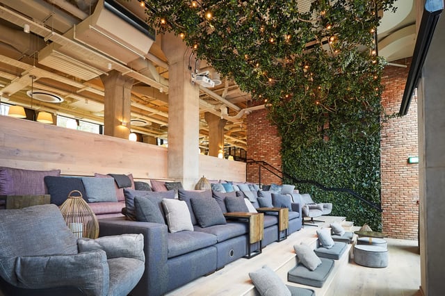 Sofa seating with wooden accents and greenery living room at Vita Student Manchester Circle Square in Manchester Student Accommodation
