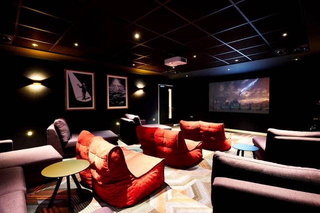 Cinema room with beanbags and projector screen playing movie at Vita Student Manchester Circle Square in Manchester Student Accommodation