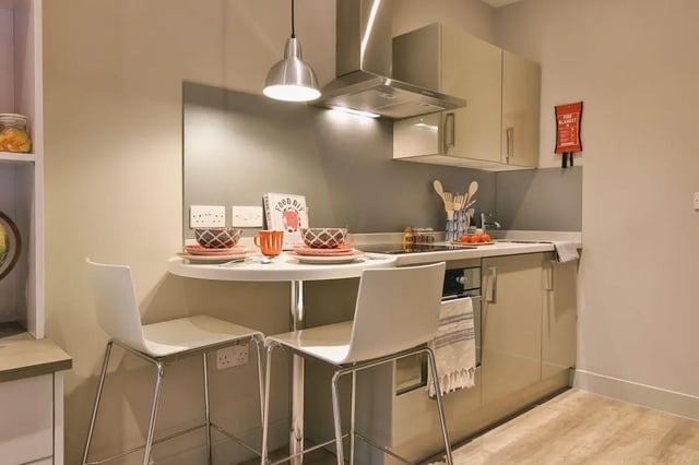 Bar table with chairs and kitchen counter kitchen at Kingsmill Studios in Huddersfield Student Accommodation