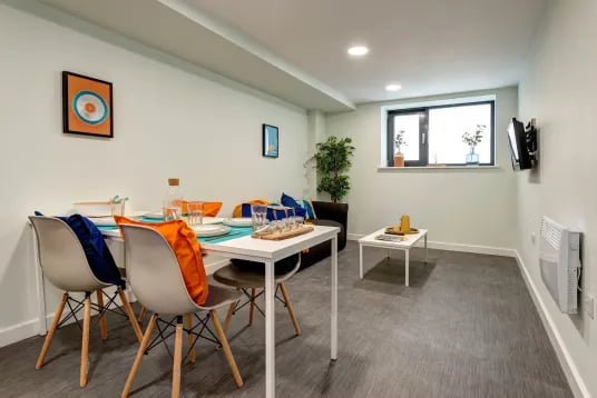 Dining table with chairs sofa and coffee table living room at Carrick View in Falmouth Student Accommodation