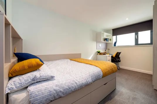 Bed desk chair shelving window bedroom at Carrick View in Falmouth Student Accommodation
