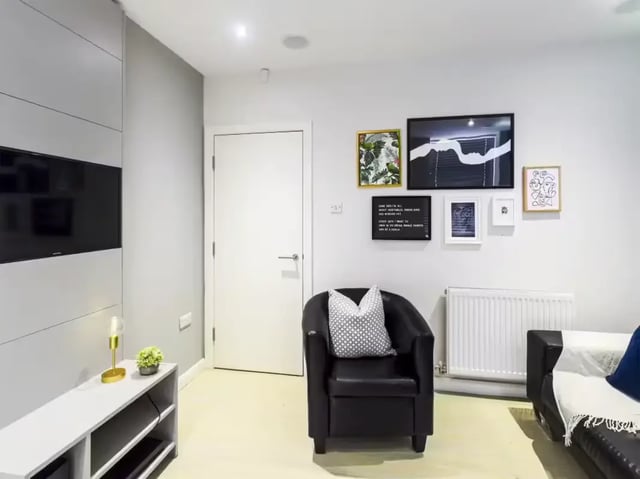 Black armchair with patterned cushion art and TV living room at 31 Guildford Street in Stoke-On-Trent Student Accommodation