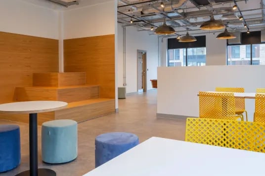 Wooden tiered seating with blue stools lounge area at Luneside in Lancaster Student Accommodation