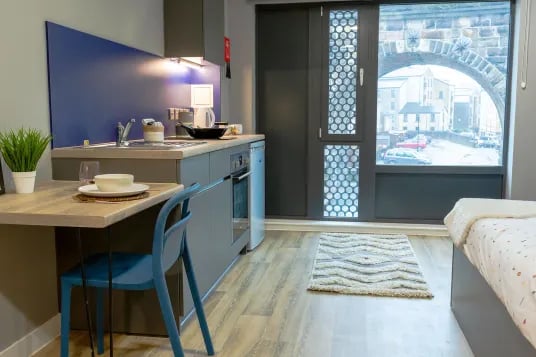 Kitchenette with table chair and bed Bedroom at Luneside in Lancaster Student Accommodation
