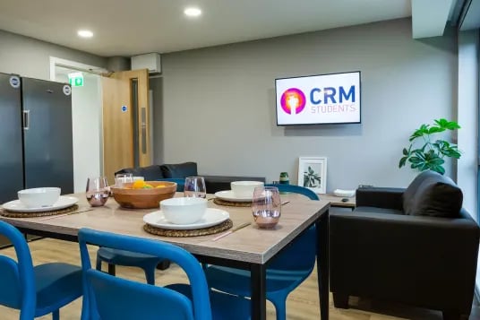 Dining table with place settings and sofa living area at Luneside in Lancaster Student Accommodation