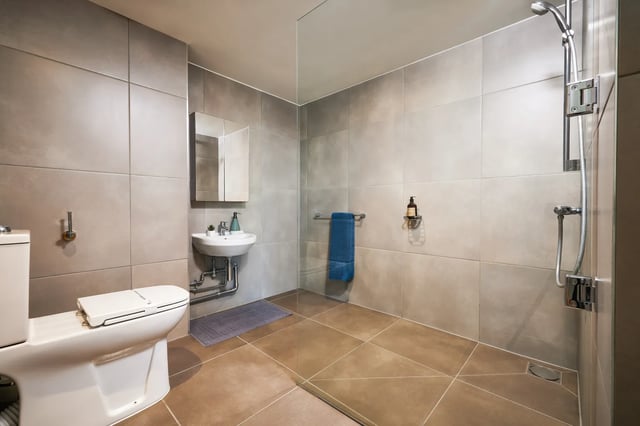 Toilet sink medicine cabinet shower and blue towel bathroom at Vita Student Newcastle Strawberry Place in Newcastle Upon Tyne Student Accommodation