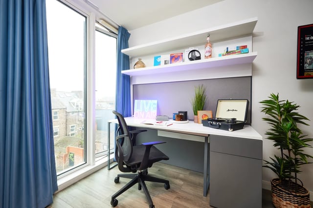 Desk chair turntable plants and neon sign study area at Vita Student Newcastle Strawberry Place in Newcastle Upon Tyne Student Accommodation