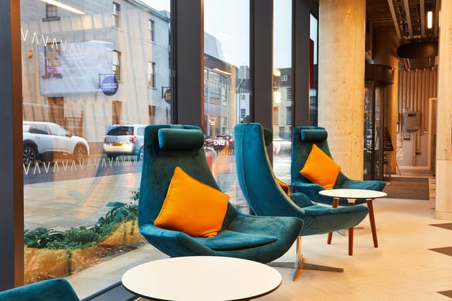 Teal chairs orange cushions white tables lounge area at Vita Student Newcastle Strawberry Place in Newcastle Upon Tyne Student Accommodation