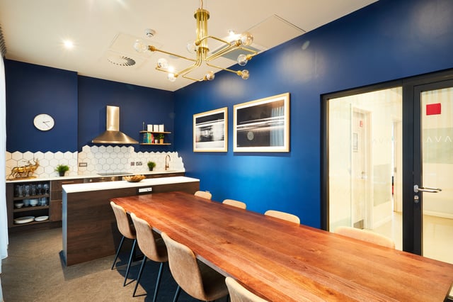 Large wooden table with chairs kitchen counter and artwork kitchen at Vita Student Newcastle Strawberry Place in Newcastle Upon Tyne Student Accommodation