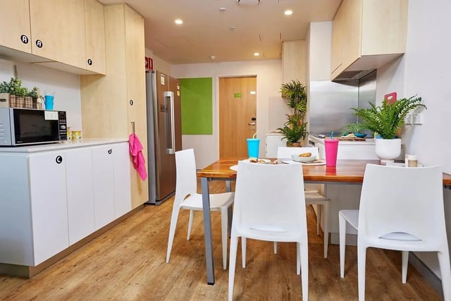 Kitchen with dining table white chairs microwave and fridge kitchen at Scape Cleveland in Sydney Student Accommodation