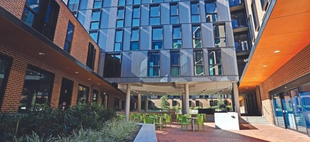 Courtyard with green chairs and tables exterior at Scape Cleveland in Sydney Student Accommodation