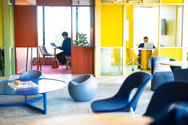 Students working laptops in colorful common area at Scape Kingsford in Sydney Student Accommodation
