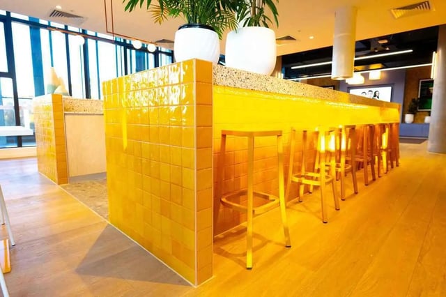 Yellow tiled bar with stools communal area at Scape Kingsford in Sydney Student Accommodation