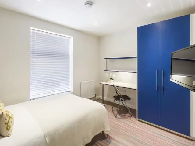 Bed desk blue wardrobe and TV bedroom at 19 Carlton Road in Stoke-On-Trent Student Accommodation