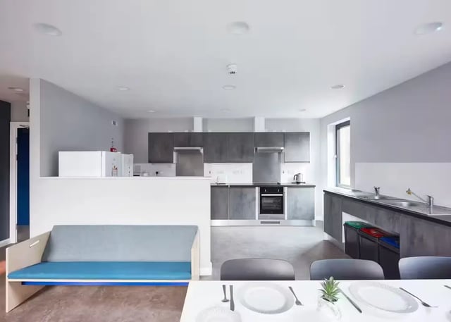 Sofa, microwaves, cabinets, oven, sink, table setting Kitchen at Alumno Falmer in Brighton Student Accommodation