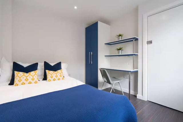 Bed with pillows desk shelves wardrobe bedroom at 16 Queen Anne Street in Stoke-On-Trent Student Accommodation