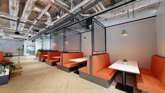 Orange booths with tables create seating areas lounge at Tribeka in Leeds Student Accommodation