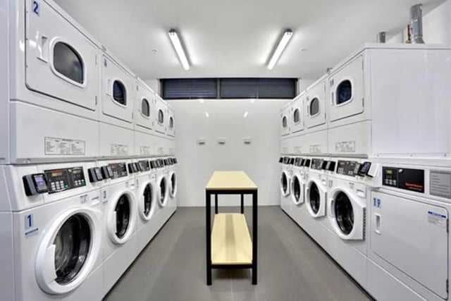 Stacked washers dryers and folding table laundry room at Scape Darling Square in Sydney Student Accommodation
