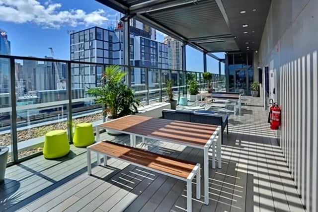 Outdoor tables benches stools and plants patio area at Scape Darling Square in Sydney Student Accommodation