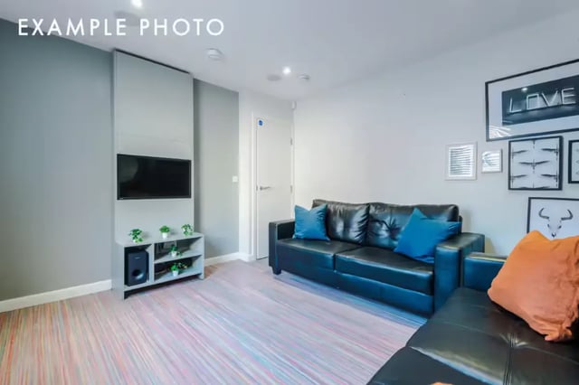 Black sofa blue pillows tv and shelves living room at 80 Beresford Street in Stoke-On-Trent Student Accommodation