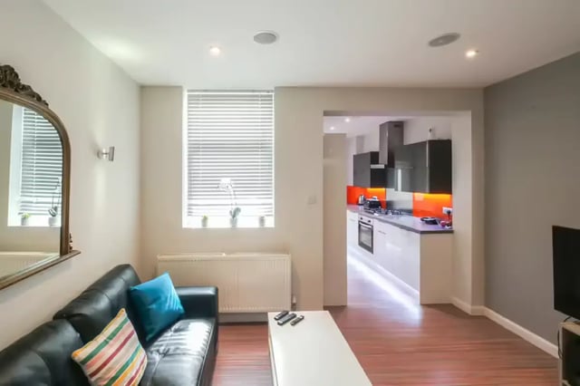 Black couch with cushions and white coffee table living room kitchen at 64 Seaford Street in Stoke-On-Trent Student Accommodation