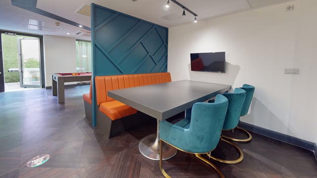 Dining area with orange booth teal chairs and table at The Residence in Coventry Student Accommodation