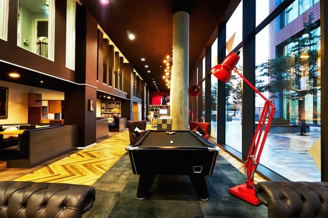Pool table, lounge seating, large red lamp, common area at Vita Student Manchester First Street in Manchester Student Accommodation